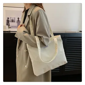 Detail of off-white corduroy tote bag with Fashion Instinct blue label for daily use