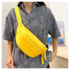 Bright yellow nylon crossbody bag shown worn by a model for size and style reference