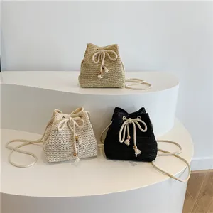 Bolsos de paja tipo cubo con cierre de cordón y borlas en tres colores diferentes