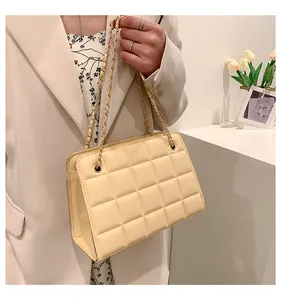 Dettaglio della borsa trapuntata beige con catena dorata e texture raffinata