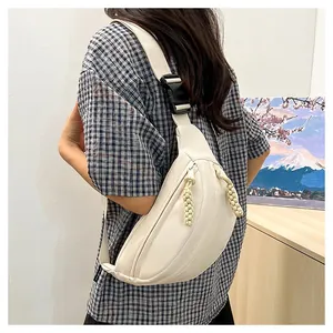 Detailed side view of off-white crossbody bag with textured zipper and adjustable strap