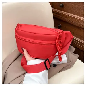 Detail of red nylon sports fanny pack showing textured fabric and rope zipper puller