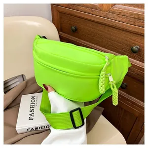 Detail of neon green nylon waist bag featuring matching rope zipper pulls and buckle strap