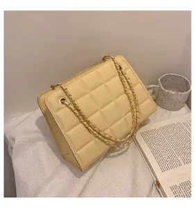 Dettaglio borsa beige trapuntata con catena dorata e texture in pelle di alta qualità