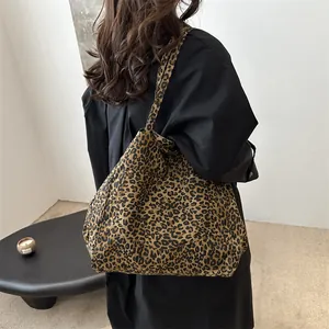 Stylish large leopard print canvas tote bag shown worn over the shoulder by a model