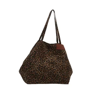 Large leopard print canvas tote bag with shoulder straps and metal rivet pocket details