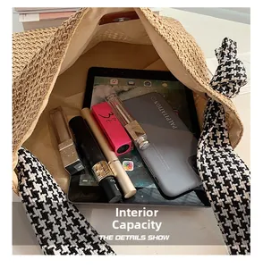 Detail showing internal capacity of straw tote bag with houndstooth strap and storage