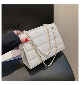 Dettaglio della borsa trapuntata bianca con catena d'oro tenuta da una modella