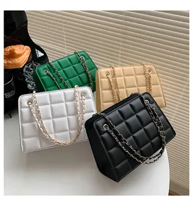 Vista dall'alto di borse trapuntate in verde, beige, bianco e nero con tracolla a catena