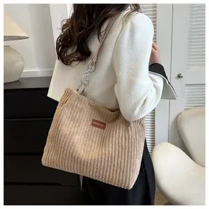 Detail of corduroy tote bag showing material texture and fashion leather label detail