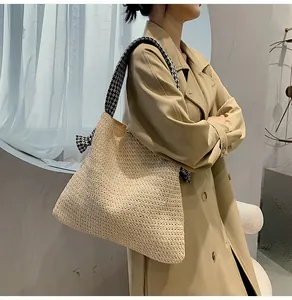 Detailed view of straw shoulder bag with houndstooth scarf on model in beige coat