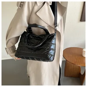 Close-up of black quilted puffer bag with glossy finish and adjustable crossbody strap