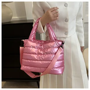 Detailed view of pink puffer bag with quilted pattern worn on white tweed outfit