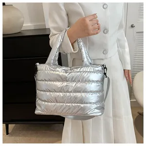 Close-up of metallic silver quilted tote bag with padded handles and sleek black hardware