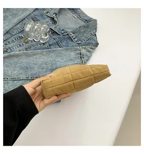 Primer plano de la textura acolchada y costuras laterales de este neceser de terciopelo caqui