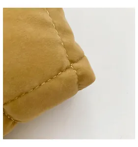 Primer plano de tela de terciopelo acolchado amarillo jengibre con costuras doradas