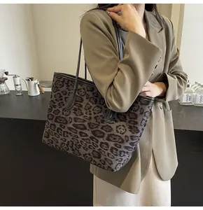 Detail of vintage leopard print tote bag with black leather straps on a model's shoulder