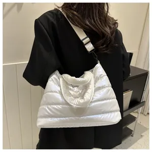 White quilted puffer bag detail featuring glossy space cotton texture and adjustable strap