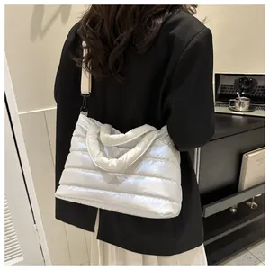 White quilted puffer handbag showing glossy nylon texture and crossbody strap on a model