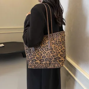 Vintage leopard print tote bag with brown straps styled on model in black coat