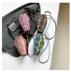 Detail of coffin-shaped PU leather crossbody bags with leopard and snake skin patterns