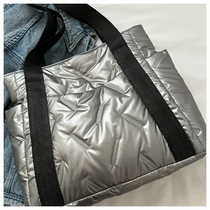 Makroaufnahme der silbernen Stepptasche mit Metallic-Struktur und schwarzen Trägern