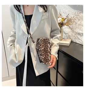 Gothic coffin-shaped leopard print crossbody bag with metallic studs on a model