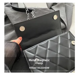 Detail showing the magnetic silver hardware clasps of the black quilted crossbody bag