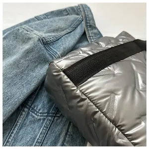 Detailansicht der silbernen Stepptasche mit Metallic-Textur und schwarzen Trägern