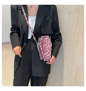 Detailed view of pink leopard print coffin bag with metallic rivets and shoulder strap