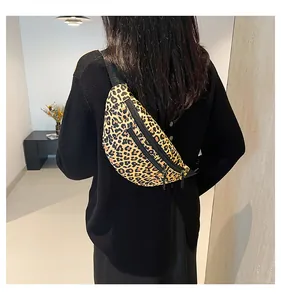 Detail of leopard print nylon crossbody bag with durable zippers shown on model