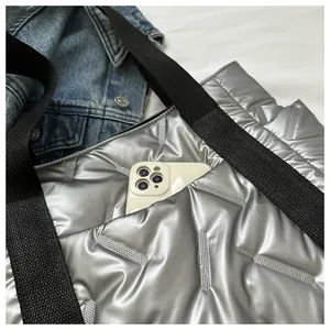 Detail der silbernen Stepptasche mit Seitentasche für ein großes Smartphone