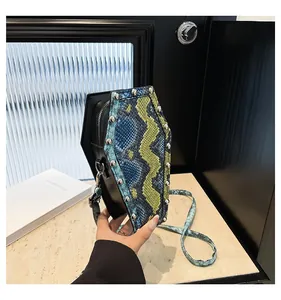 Macro view of coffin shaped shoulder bag with faux snakeskin texture and silver studs