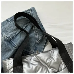 Detail der silbernen Stepptasche mit Metallic-Effekt und schwarzem Nylon-Gurtband