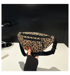 Detail view of leopard print nylon chest bag featuring dual zippers and adjustable black strap