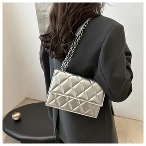 Silver quilted chain bag shown on a grey blazer for a modern urban aesthetic