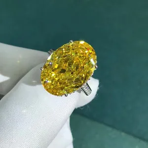 Macro shot of 30ct oval cut yellow gemstone ring held with white jewelry gloves