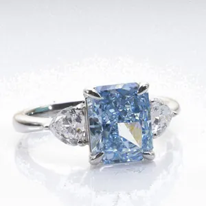 Radiant cut blue carbon diamond ring with side pear stones in silver four-claw setting
