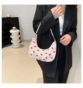 Pink corduroy crescent bag with red strawberry print and pearl strap detail