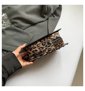 Detail view of leopard print coffin bag featuring silver studs and metal zipper hardware