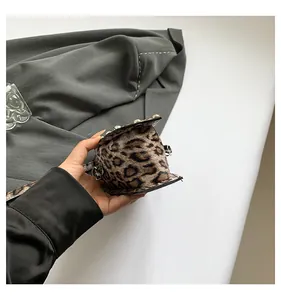 Detail of leopard print plush bag with gold studs and adjustable shoulder strap