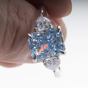 Macro shot of a radiant cut blue carbon diamond ring with pear-shaped side stones