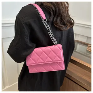 Detailed close-up of quilted pink shoulder bag with elegant silver chain strap and leather