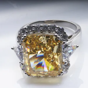 Macro shot of 10-carat radiant cut yellow gemstone ring with trillion side stones