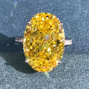 Macro detail of oval cut yellow gemstone ring with pavé diamond band on textured fabric
