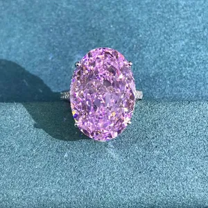 Close-up of 30ct oval cut pink sparkling gemstone ring with diamond encrusted band
