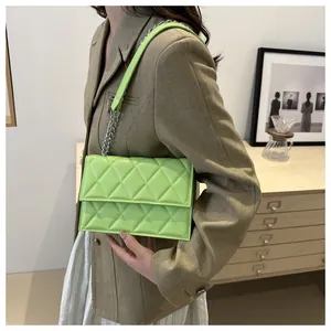 Detail showing neon green quilted rhombic pattern and silver chain strap on the bag