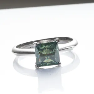 925 silver ring with 4-prong princess cut blue-green moissanite on white mirror surface