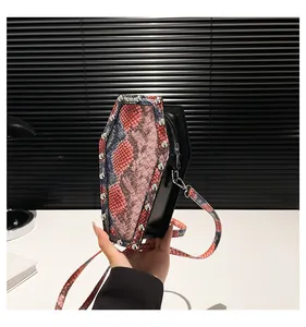 Macro detail of coffin shaped crossbody bag with colorful snakeskin texture and silver rivets