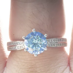 Blue moissanite six-prong silver ring with double-layered split band on finger